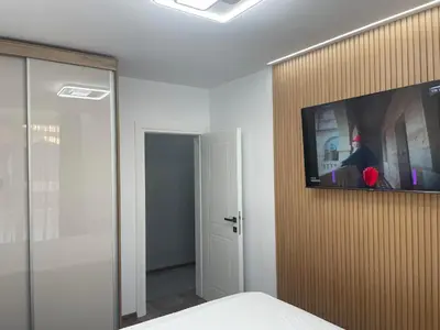 a room with a tv on a wall with a bed at Flat Park Sandanski in Sandanski