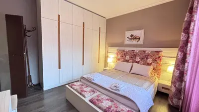 a small bedroom with a bed with pink curtains at Stylish 2 BR apart in top center in Sofia