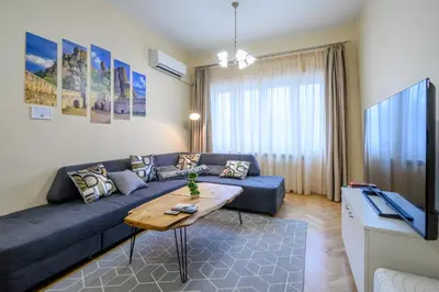 a living room with a blue couch and a table at Grand Luxury Condo by NDK and National Stadium with Free Parking in Sofia