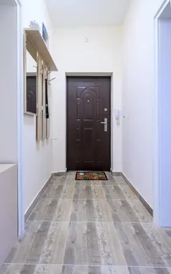 a hallway with a black door and a tile floor at Grand Luxury Condo by NDK and National Stadium with Free Parking in Sofia