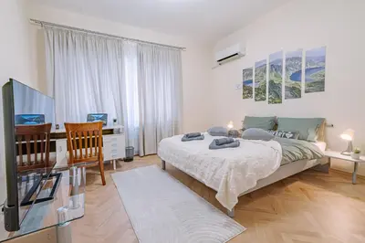a bedroom with a bed and a desk and a tv at Grand Luxury Condo by NDK and National Stadium with Free Parking in Sofia