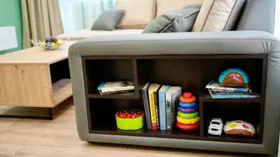 a book shelf in a couch with books and toys at Downtown Gem in Plovdiv