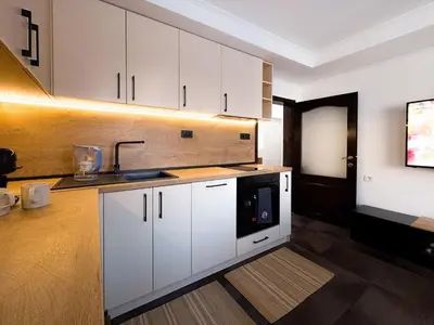 a kitchen with white cabinets and a black microwave at Serenity Apartment Bansko in Bansko