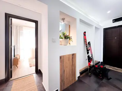 a hallway with a room with skis on the wall at Serenity Apartment Bansko in Bansko