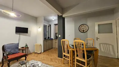 a dining room with a table and chairs and a clock at Colorful 2BD Apartment next to Serdika Center by Flat Mаnager in Sofia