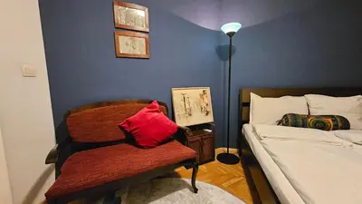 a bedroom with a bed and a chair with a red pillow at Colorful 2BD Apartment next to Serdika Center by Flat Mаnager in Sofia
