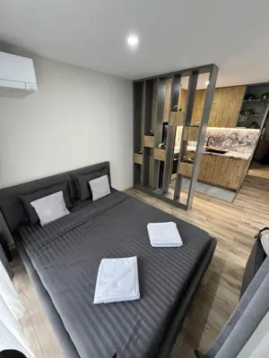 a bedroom with a black bed with towels on it at July apartaments in Velingrad