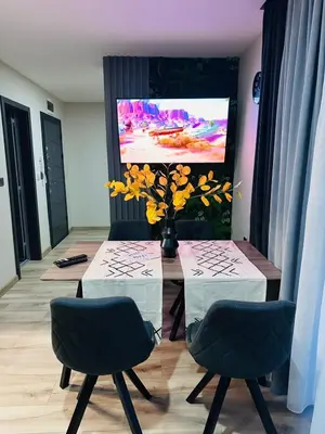 a dining room with a table and two chairs and a screen at July apartaments in Velingrad