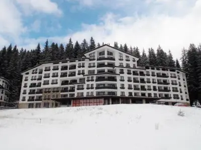 a large building on top of a snow covered slope at Apartment Geronimo in Pamporovo