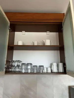 a kitchen shelf with jars and cups on it at Apartment Geronimo in Pamporovo
