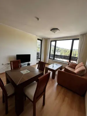 a living room with a table and a couch at Apartment Geronimo in Pamporovo