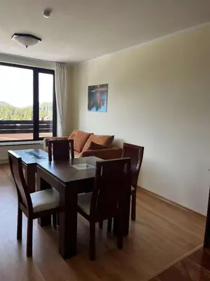 a living room with a table and a couch at Apartment Geronimo in Pamporovo