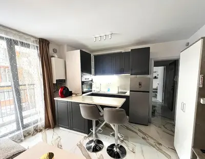 a kitchen with black cabinets and a kitchen island with stools at Sirius Apartment in Sofia