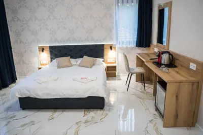 a hotel room with a bed and a desk and a desk at Хотелски комплекс Релакс in Rudozem