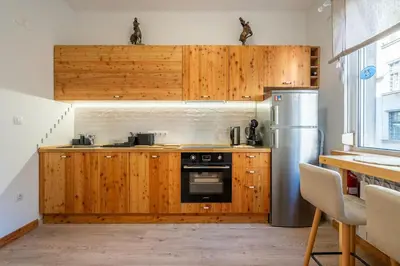 a kitchen with wooden cabinets and a refrigerator at A central retreat in the heart of Sofia in Sofia