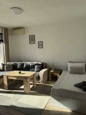 a living room with a bed and a couch at Апартамент Слънчев дом in Smolyan