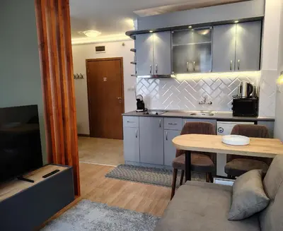 a kitchen and dining room with a table and a couch at Ski lift studio in Bansko