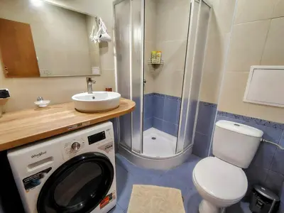 a washing machine in a bathroom with a shower at Ski lift studio in Bansko