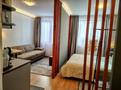 a small living room with a bed and a couch at Ski lift studio in Bansko