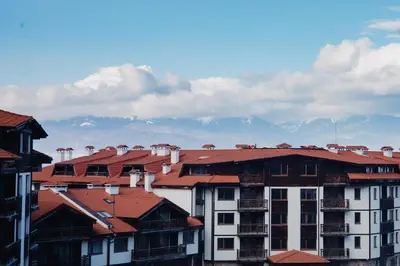a group of buildings with mountains in the background at Pirin Peaks Residence - next to Ski Lift in Bansko
