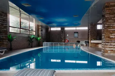 a large swimming pool with a blue ceiling at Rila Residence - next to Pirin Golf in Razlog