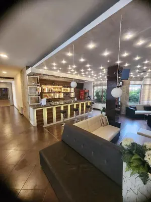 a large living room with a couch and a kitchen at Rila Residence - next to Pirin Golf in Razlog