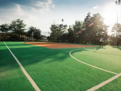 a man is playing tennis on a tennis court at Villa Leventy in Banya