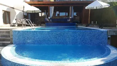 a swimming pool with blue tiles on the ground at Villa Leventy in Banya