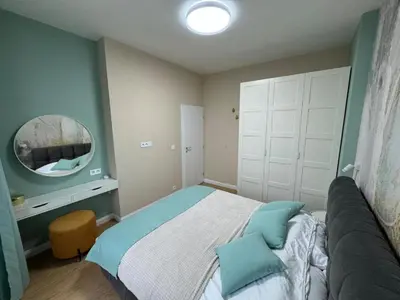 a small bedroom with a bed and a mirror at Homely Apartment in Lozenets Sofia in Sofia