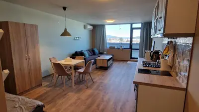 a kitchen and living room with a table and a couch at Cosy n fully equipped studio in Samokov
