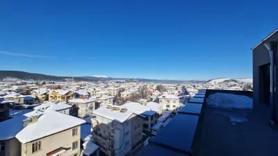 a city with snow on the roofs of buildings at Cosy n fully equipped studio in Samokov