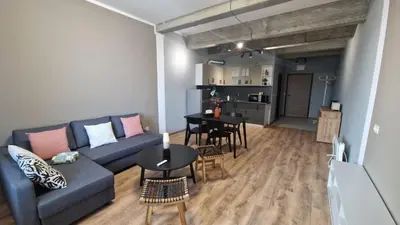 a living room with a blue couch and a table at Concrete comfort in Samokov