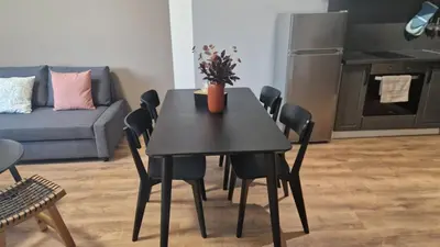 a black table and chairs in a living room at Concrete comfort in Samokov