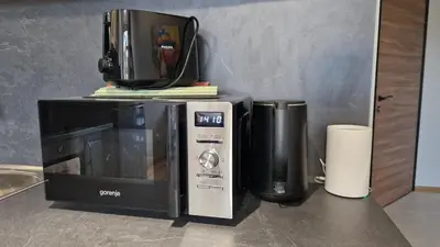 a microwave and a coffee maker next to a toaster oven at Concrete comfort in Samokov