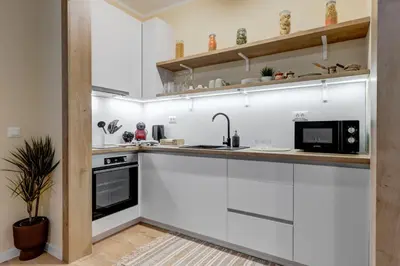 a kitchen with white cabinets and a sink at Veslets 4 Oldtown Stay in Sofia