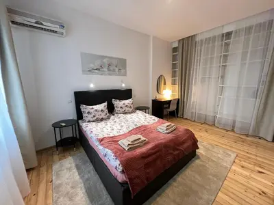 a bedroom with a bed with a red comforter at Florence family 2BDR Apt - min from Serdika w WiFi in Sofia