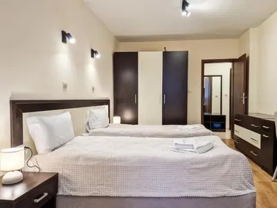 a bedroom with two beds with white sheets and a table at Relaxing Stay in Kosara Bansko Near Ski Lift by Flat Mаnager in Bansko