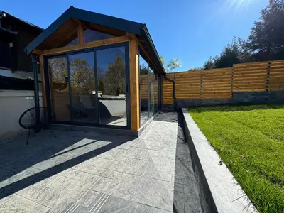 a pavilion with a glass door on a patio at Вила Mountain Ship in Dedovo