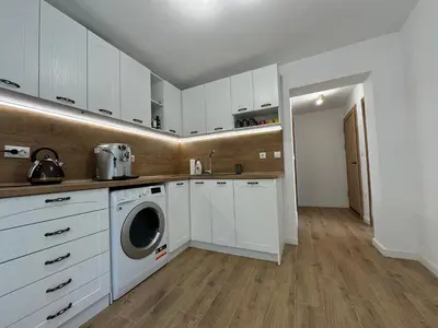 a kitchen with white cabinets and a washing machine at Вила Mountain Ship in Dedovo