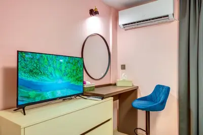 a living room with a tv and a blue chair at Апартамент за гости Райково in Smolyan