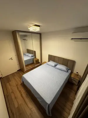 a bedroom with a bed and a large mirror at Atayana Apartment in Sofia