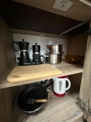 a shelf with pots and pans on top at Atayana Apartment in Sofia