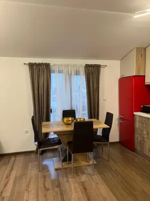 a dining room with a table and chairs and a kitchen at Atayana Apartment in Sofia