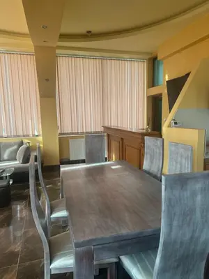 a dining room with a wooden table and chairs at arartment in Kostandovo
