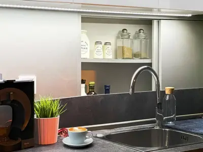 a kitchen counter with a sink and a cup of coffee at Center Stay Stylish 2BR near Serdika Metro in Sofia