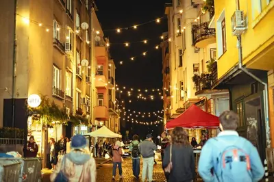 a group of people walking down a city street at night at Center Stay Stylish 2BR near Serdika Metro in Sofia