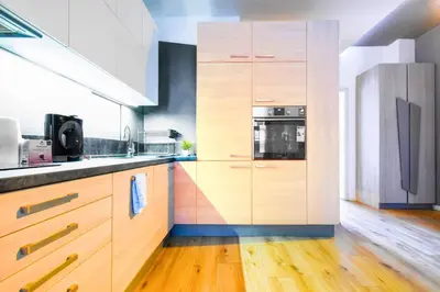 a kitchen with wooden cabinets and a stove at Center Stay Stylish 2BR near Serdika Metro in Sofia