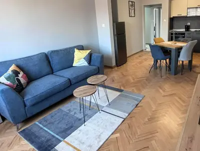 a living room with a blue couch and a table at Боко 16-18 in Sofia