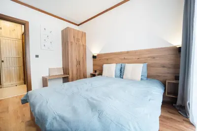 a bedroom with a large bed with a wooden headboard at Host2U Highland Hideaway Bansko in Bansko