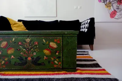 a green chest sitting on a rug next to a couch at Host2U Art AP - Fireplace - Free parking - 5min Gondola in Bansko